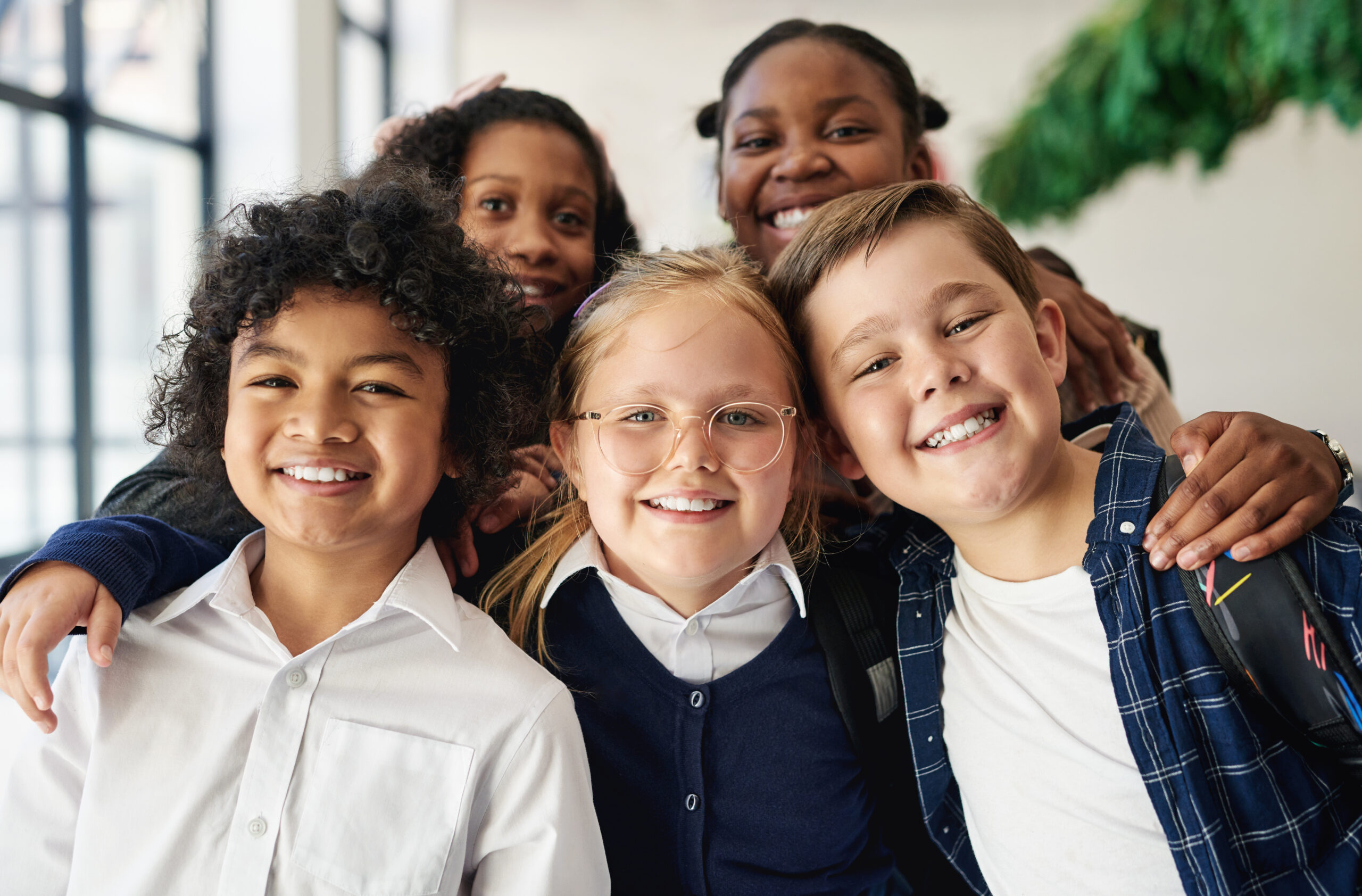 Shot of a diverse group of children standing together in the hallway at school during the day.