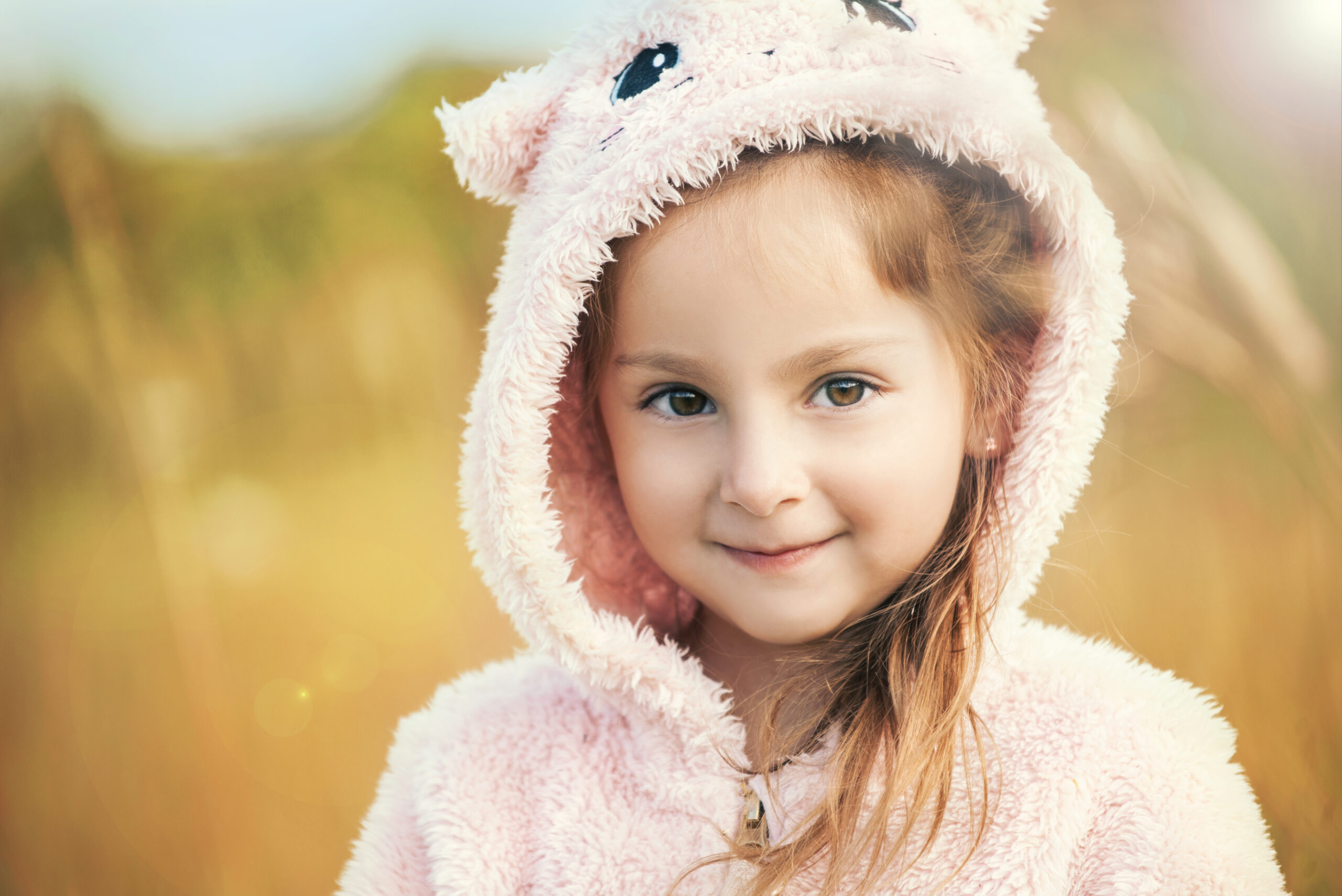 Close-up portrait of a charming brown-eyed five-year-old girl walking on a street on a warm summer evening. The concept of naive children