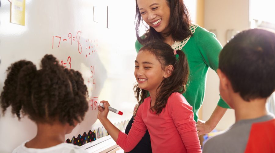 Pupil writing on the board at elementary school maths class
